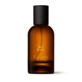 Amber glass Aesop Tacit Truths Eau de Parfum bottle with black cap on a white background.